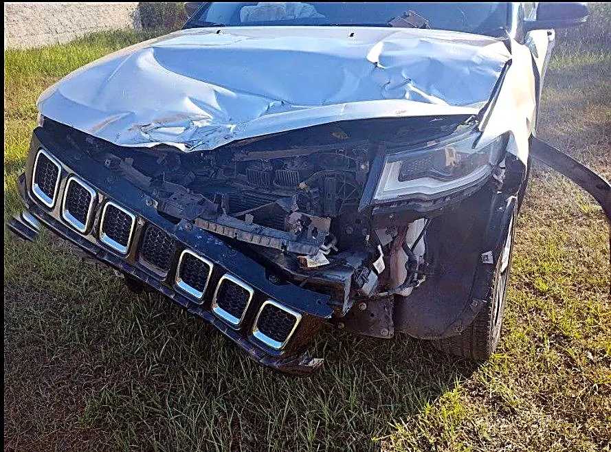 Jeep Compass com a frente destruída e o capô amassado antes do reparo